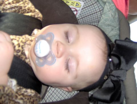 1978 Ford Bronco - A baby sleeps soundly in a car seat, wearing a leopard print outfit and a large black bow.
