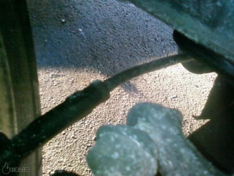 1991 Nissan 240SX - A close-up view of a vehicle's suspension system, showing a metal line and mechanical components.