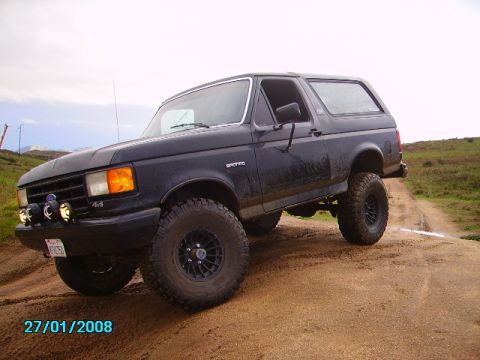 1990 Ford Bronco - This black 1990 Ford Bronco is shown on a dirt road, equipped with off-road tires and a lifted suspension.