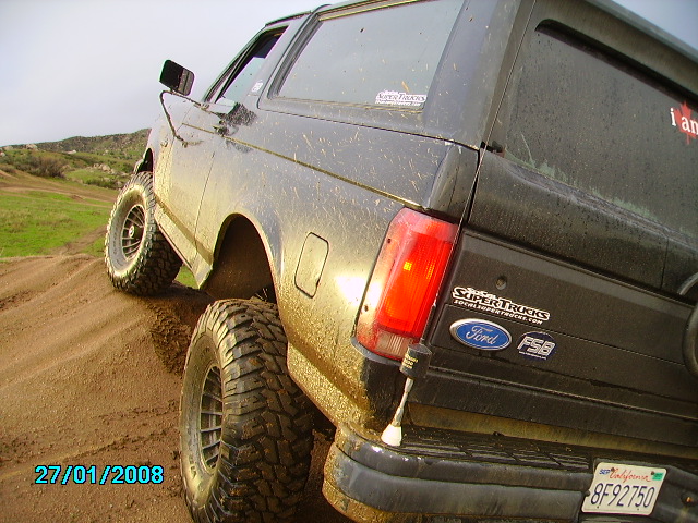 1990 Ford Bronco climbing a dirt mound, rear view showing SuperTrucks and Ford FSB decals