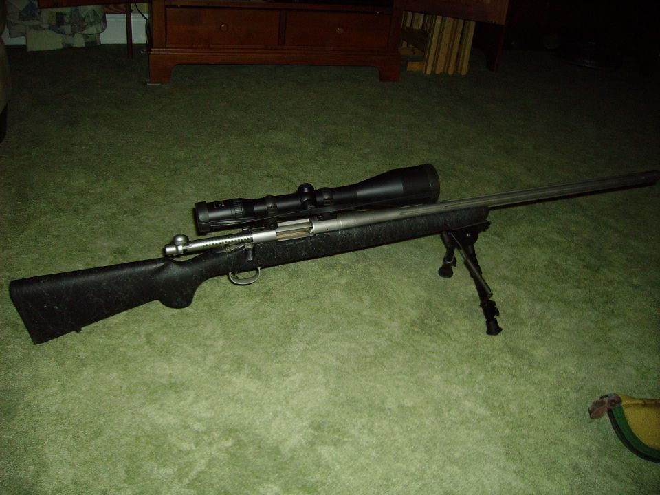 Rifle with scope and bipod on green carpet