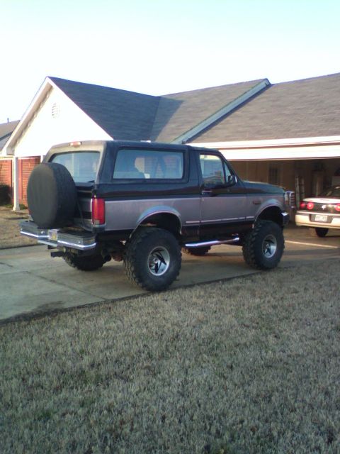 1995 Ford Bronco - This lifted 1995 Ford Bronco is parked in front of a residential building with a spare tire mounted on the back.