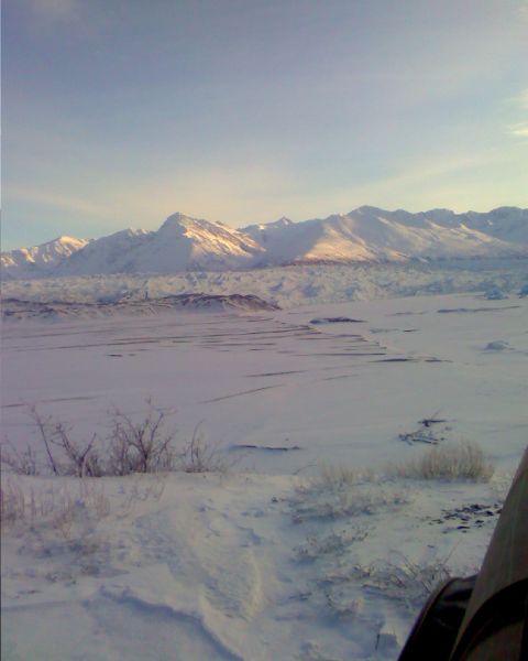 1990 Ford F-250 - A vast snowy landscape stretches towards snow-capped mountains under a clear sky.