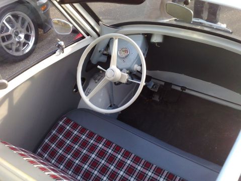 1991 Ford Crown Victoria - Interior view of a classic microcar, with a plaid seat and a glimpse of another vehicle outside.