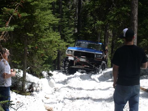 1979 Ford Bronco - A blue 1979 Ford Bronco navigates a snowy trail with a winch attached to the front.