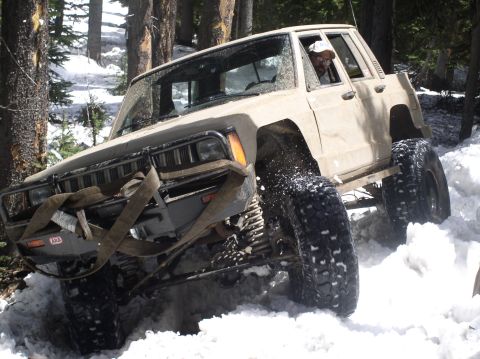 1979 Ford Bronco - This modified SUV navigates a snowy, wooded terrain with its large tires kicking up snow.
