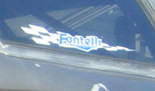 1990 Ford Bronco - A close-up of a vehicle window shows a 'Fantelli' sticker with a checkered flag design.