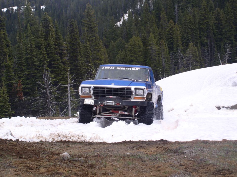 1979 Ford Bronco driving through snow with trees in background. Decal on windshield reads 'BIG BR NOOR 4x4 CLUB'