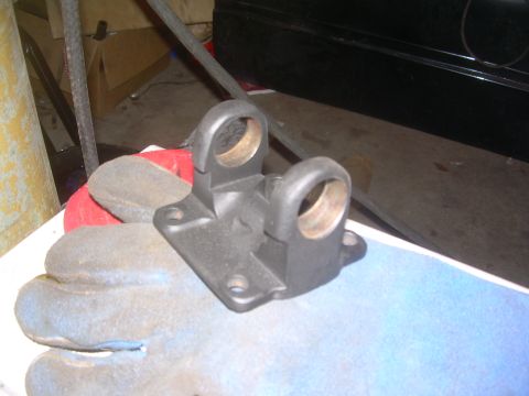 1993 Toyota 4Runner - A black metal bracket with two circular openings, likely a vehicle part, is held by a gloved hand.