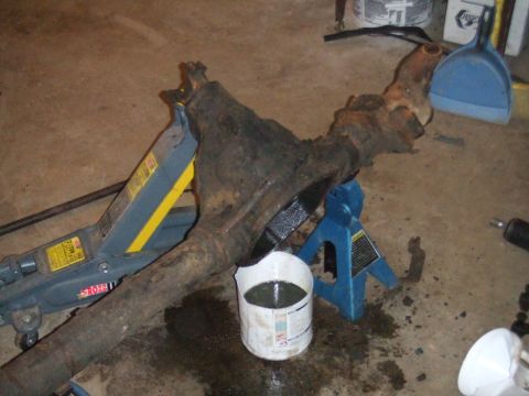1996 Ford Bronco - A differential axle assembly, likely from a 4x4 vehicle, is supported by jack stands in a garage setting.