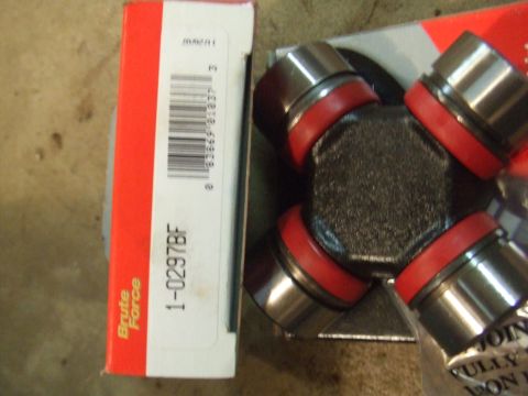 1996 Ford Bronco - A universal joint with red seals sits beside its packaging, which is labeled with part number 1-0297BF and the brand 'Brute Force' brand.