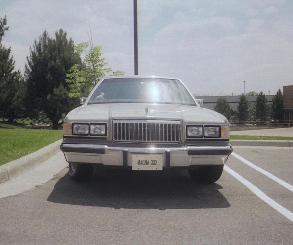 Front view of a silver Mercury sedan with MAGNA 302 plate