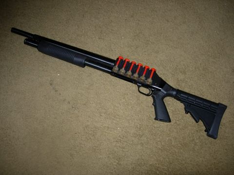 1993 Ford Bronco - Shotgun with a shell carrier loaded with seven shells is displayed on a carpeted floor.