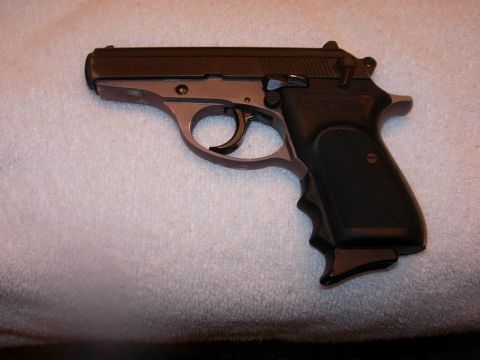 1993 Ford Bronco - A close-up view of a semi-automatic pistol resting on a textured surface.