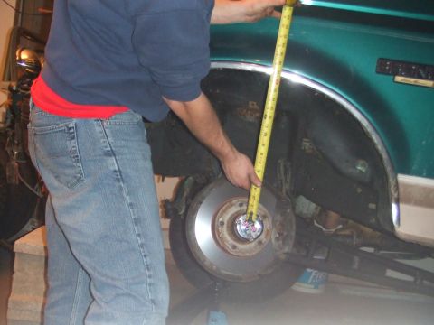 1996 Ford Bronco - A person is measuring the suspension of a vehicle, possibly for repair or modification.