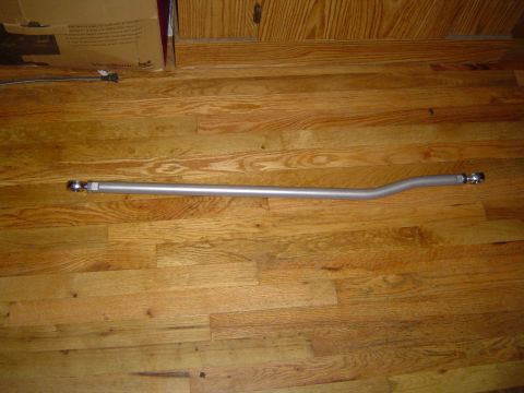 1978 Ford Bronco - A silver sway bar with threaded ends and ball joints is shown on a wooden floor.