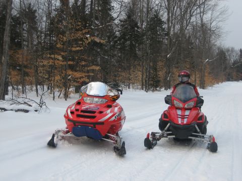 1995 Ford Bronco - Two snowmobiles are ready for a ride on a winter trail.