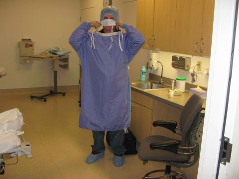 1987 Suzuki Samurai - A person prepares to put on a surgical gown in a medical facility room.