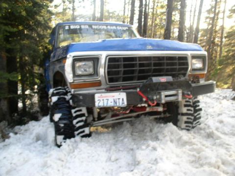 1979 Ford Bronco - 1979 Ford Bronco navigates snowy terrain with a front-mounted winch.
