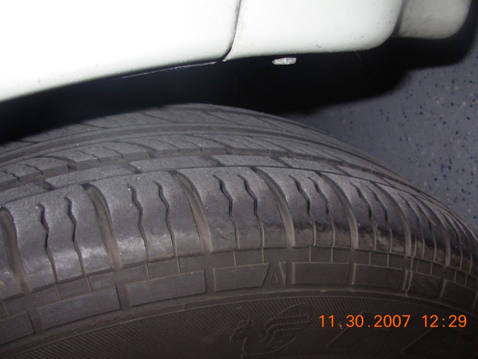 Close-up of a tire and white lower body panel. Timestamp 11.30.2007