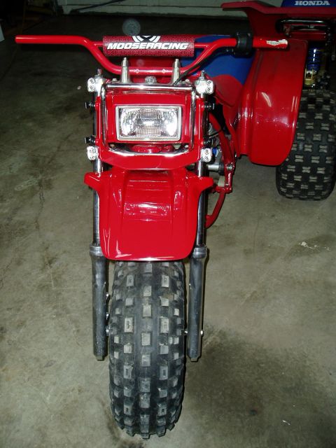 2000 Ford E350 - A red three-wheeled ATV is shown from the front, Moose Racing handlebars and a large front tire.