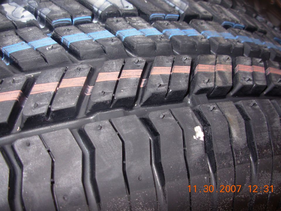 Close-up of tire tread with blue and orange markings