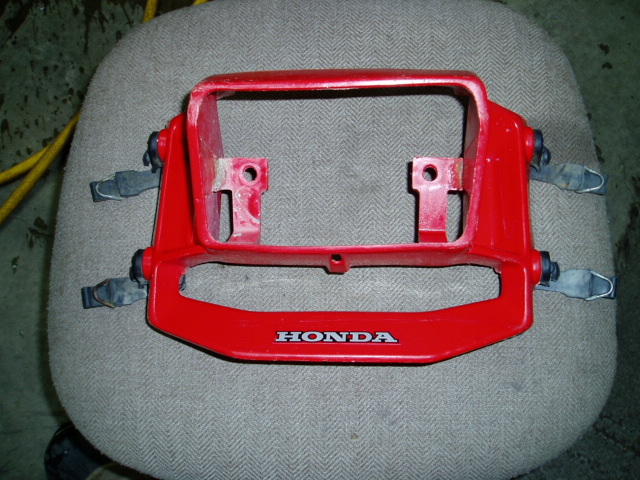 Red plastic Honda part with mounting brackets and a visible "HONDA" logo