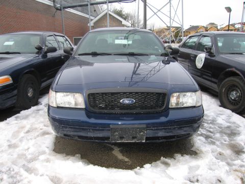1991 Ford LTD Crown Victoria - Two Ford Crown Victoria police cars are parked side-by-side in the snow.