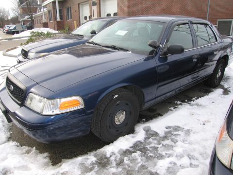 1991 Ford LTD Crown Victoria - A dark blue Ford Crown Victoria police car is parked outside in the snow, with another similar vehicle behind it.