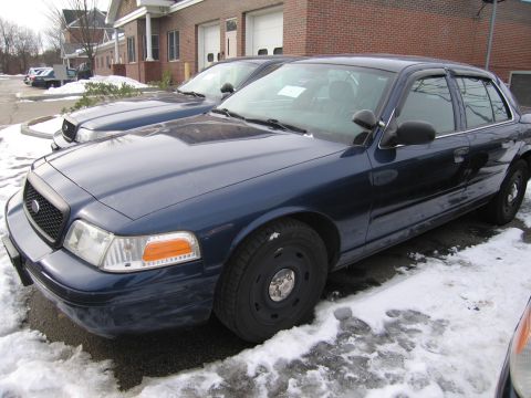 1991 Ford LTD Crown Victoria - A dark blue sedan sits in a snowy lot, partially obscured by snow and ice.
