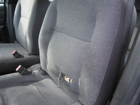 1991 Ford LTD Crown Victoria - Interior of a car showing a damaged seat and seat belts.