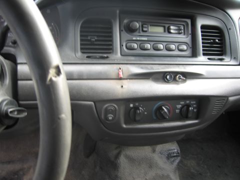 1991 Ford LTD Crown Victoria - The interior of a car shows the dashboard with a damaged steering wheel and various controls.