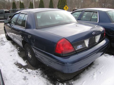1991 Ford LTD Crown Victoria - A dark blue Ford Crown Victoria sedan is parked in the snow, showing its rear and side profile.