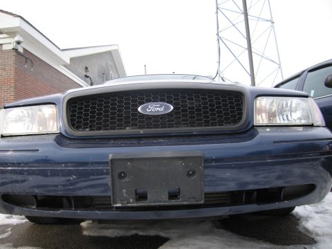 1991 Ford LTD Crown Victoria - Front view of a blue Ford Crown Victoria with a honeycomb grille and Ford emblem.