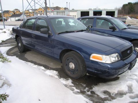 1991 Ford LTD Crown Victoria - A dark blue sedan, possibly a 1991 Ford Crown Victoria LTD, is parked in a snowy lot next to another similar vehicle.