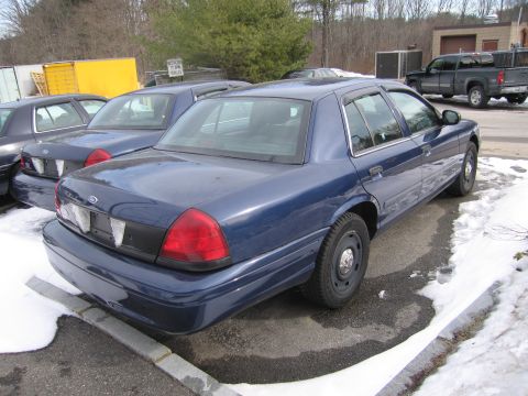 1991 Ford LTD Crown Victoria - Multiple blue Ford Crown Victoria sedans are parked in an outdoor lot during winter.