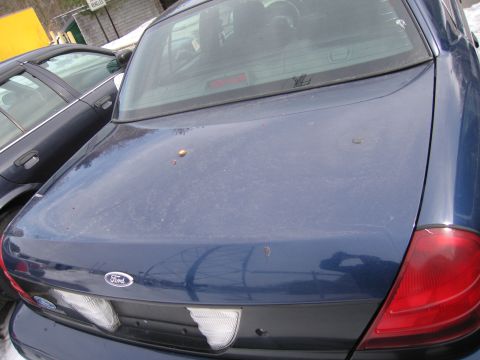 1991 Ford LTD Crown Victoria - The rear of a blue Ford Crown Victoria is visible, parked outdoors next to another vehicle.