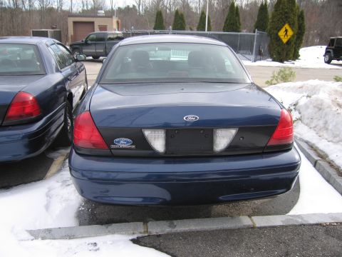 1991 Ford LTD Crown Victoria - Two dark blue Ford Crown Victoria Police Interceptors are parked side-by-side in a snowy lot.