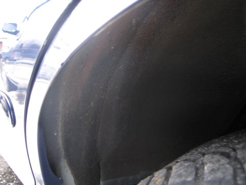 1991 Ford LTD Crown Victoria - The image shows the interior of a vehicle's wheel well and a portion of the tire.