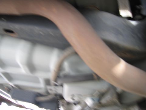 1991 Ford LTD Crown Victoria - The underside of a vehicle is visible, with a focus on the exhaust system and frame components.