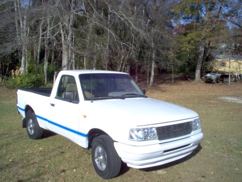 1993 Ford Ranger - This pickup truck has a distinctive grille and headlight design, and blue pinstriping along its side.