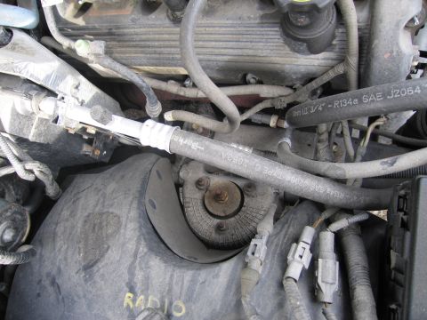 1991 Ford LTD Crown Victoria - Close-up view of a car's engine bay, showing various hoses and electrical connectors.