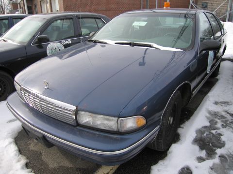 1991 Ford LTD Crown Victoria - A blue sedan with a prominent chrome grille sits parked in the snow next to another vehicle.