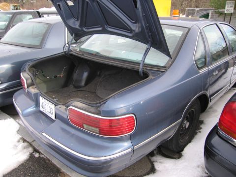 1991 Ford LTD Crown Victoria - A blue sedan's trunk is open, revealing its interior and wiring.