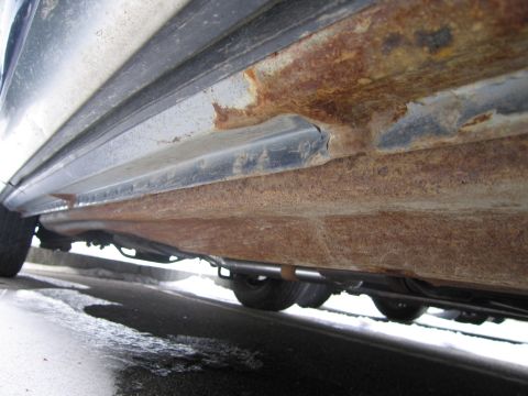 1991 Ford LTD Crown Victoria - The lower body panels and frame of the vehicle are heavily corroded with rust.