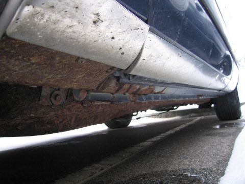 1991 Ford LTD Crown Victoria - The undercarriage of a 1991 Ford Crown Victoria LTD shows significant rust damage on the rocker panel.