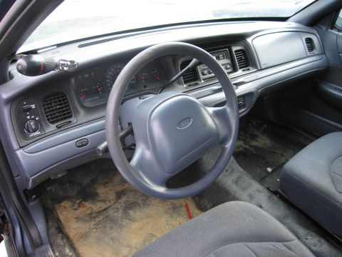 1991 Ford LTD Crown Victoria - The interior of a Ford Crown Victoria shows the dashboard, steering wheel, and seats. The floor is covered in dirt and debris.
