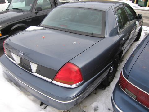 1991 Ford LTD Crown Victoria - A dark blue Ford Crown Victoria is parked in the snow, viewed from the rear.