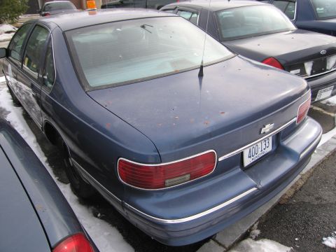 1991 Ford LTD Crown Victoria - Rear view of a blue sedan, possibly a Chevrolet Caprice, with a license plate reading 400-133.
