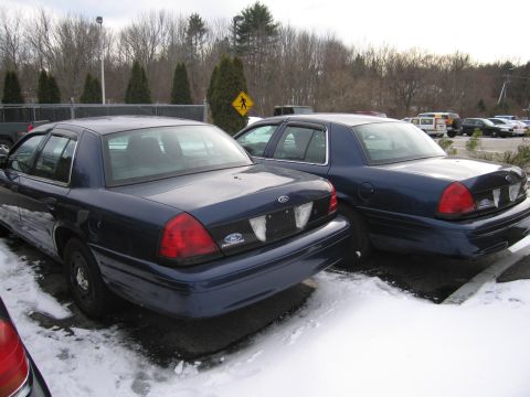 1991 Ford LTD Crown Victoria - Two Ford Crown Victoria police cars are parked side-by-side in a snowy lot.